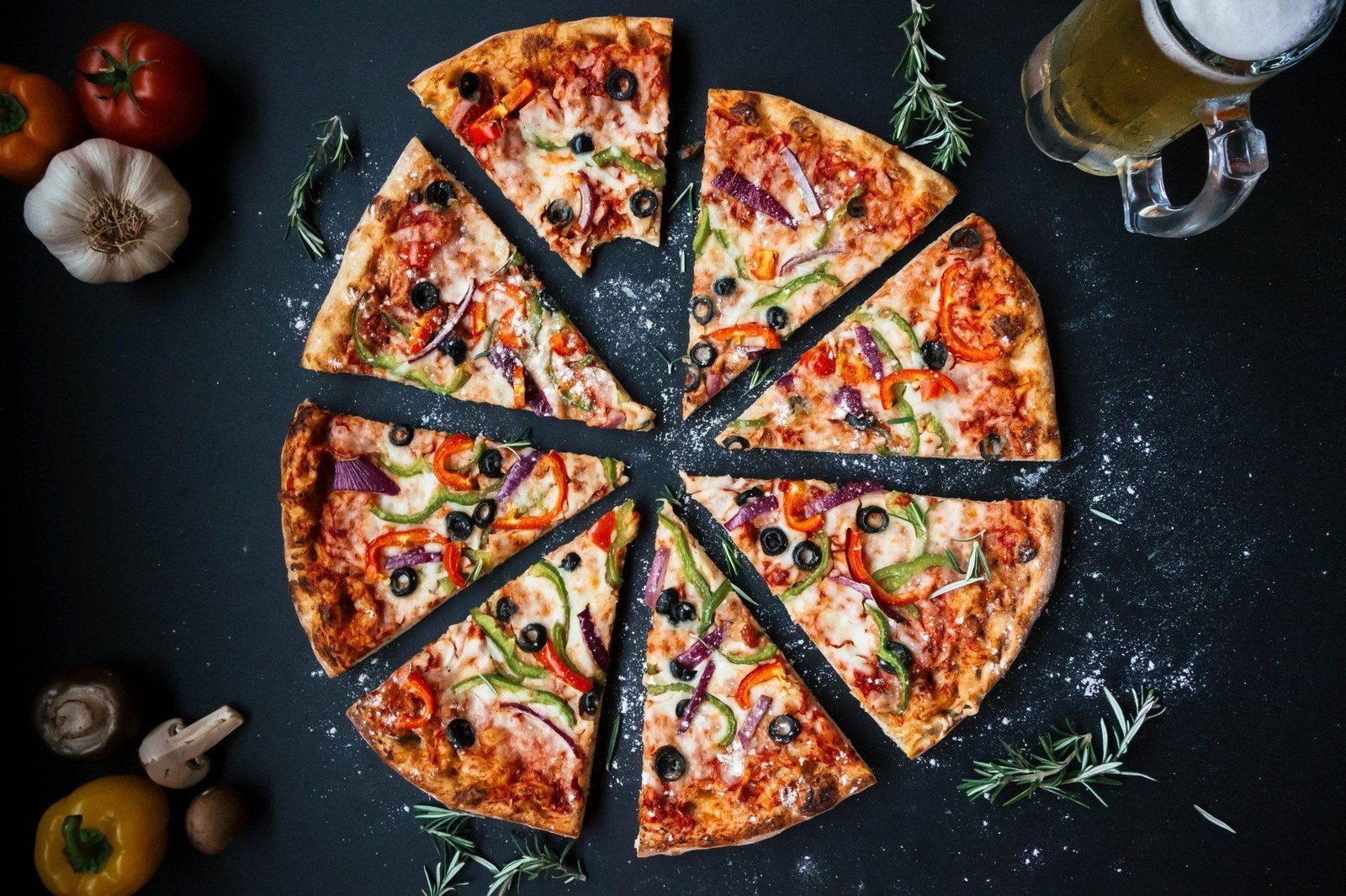Sliced veggie pizza with olives, peppers and onion
